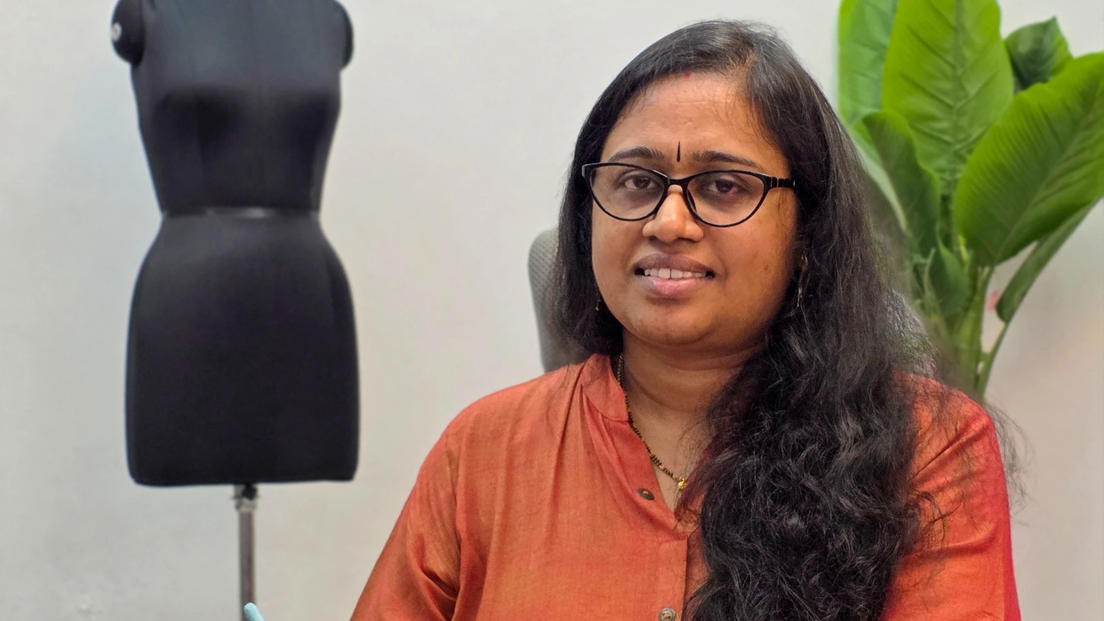 Sailakshmi, founder of Savitur, folding a saree in the showroom